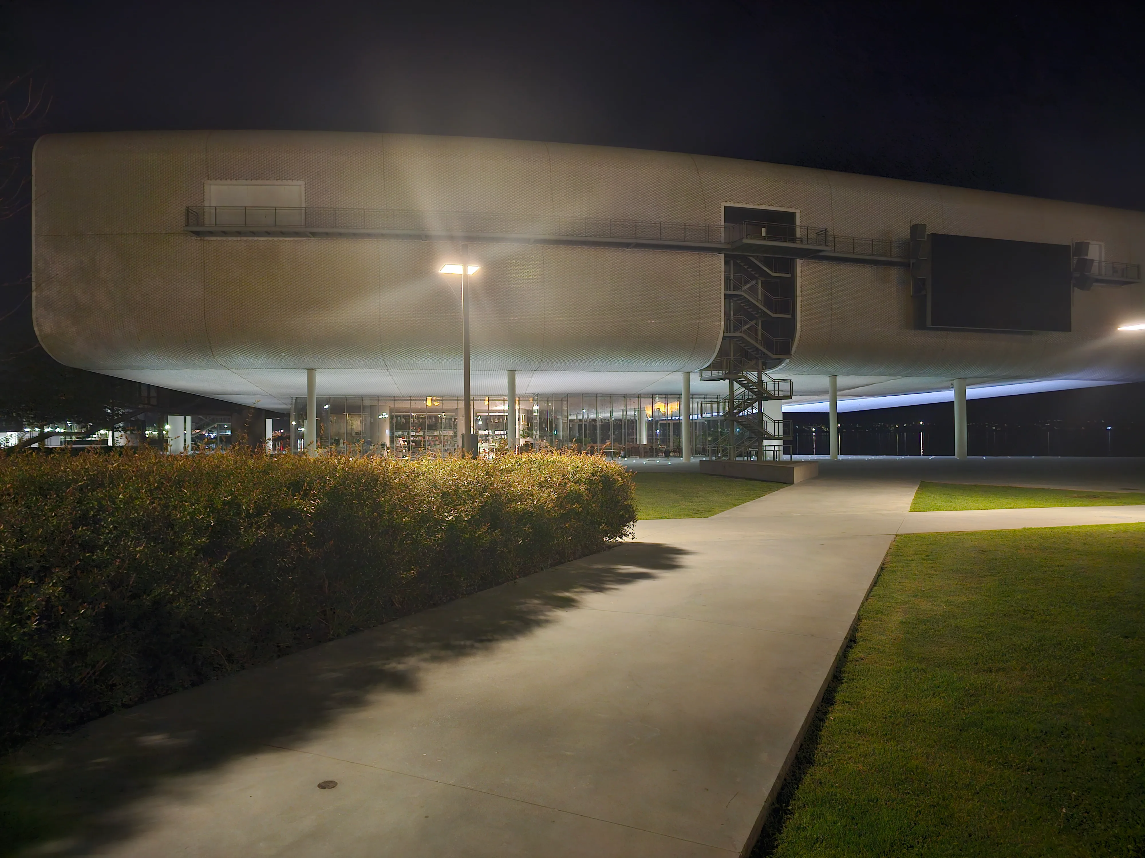 Centro Botín de Santander iluminado de noche visto desde el jardín con césped